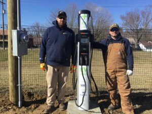 VEC’s Gabe Durham, and John Schoeder stand beside the new dual point EV charging station.